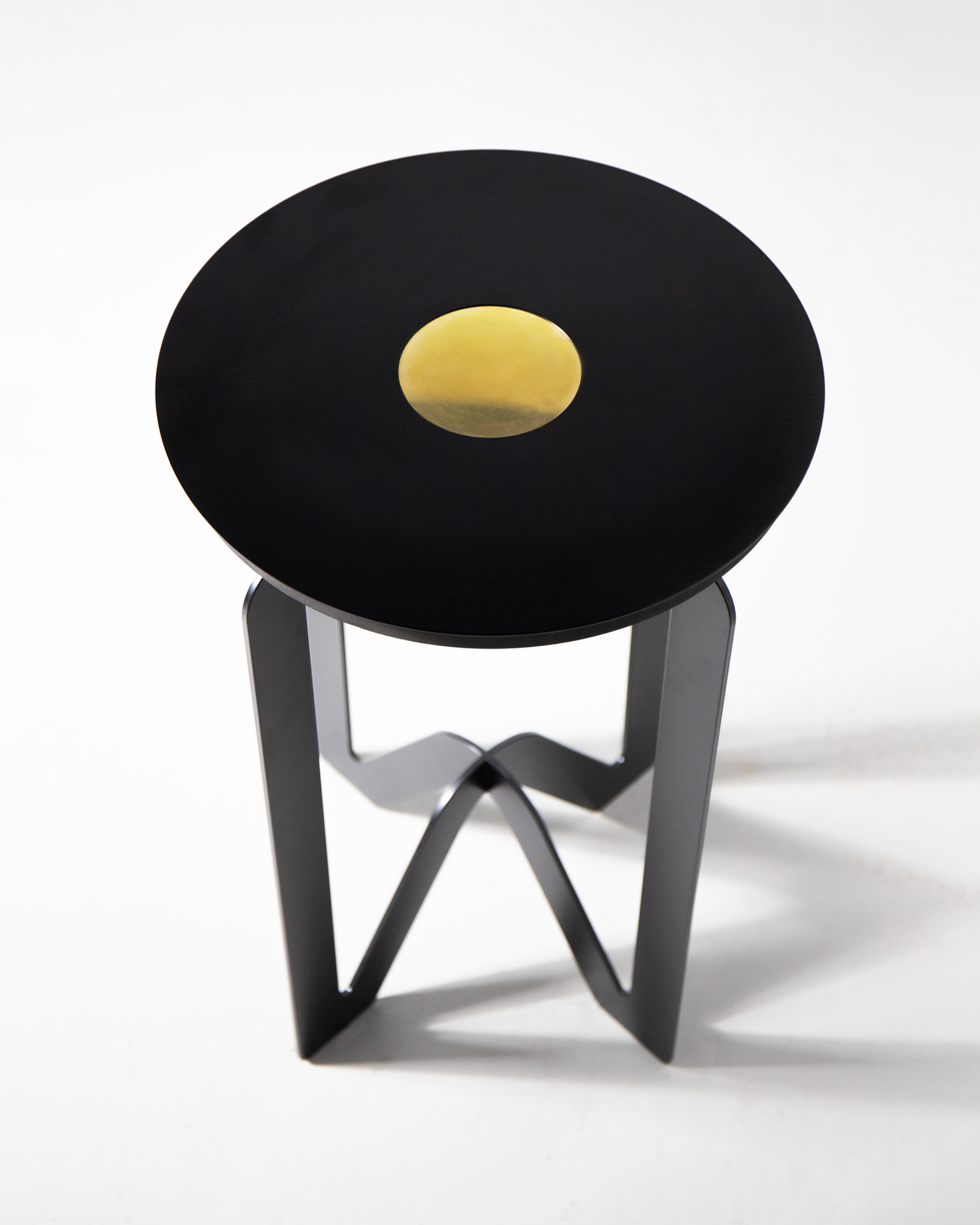 The W table, a black and brass metal table in the shape of a W, by Kyle Wilkinson Studio