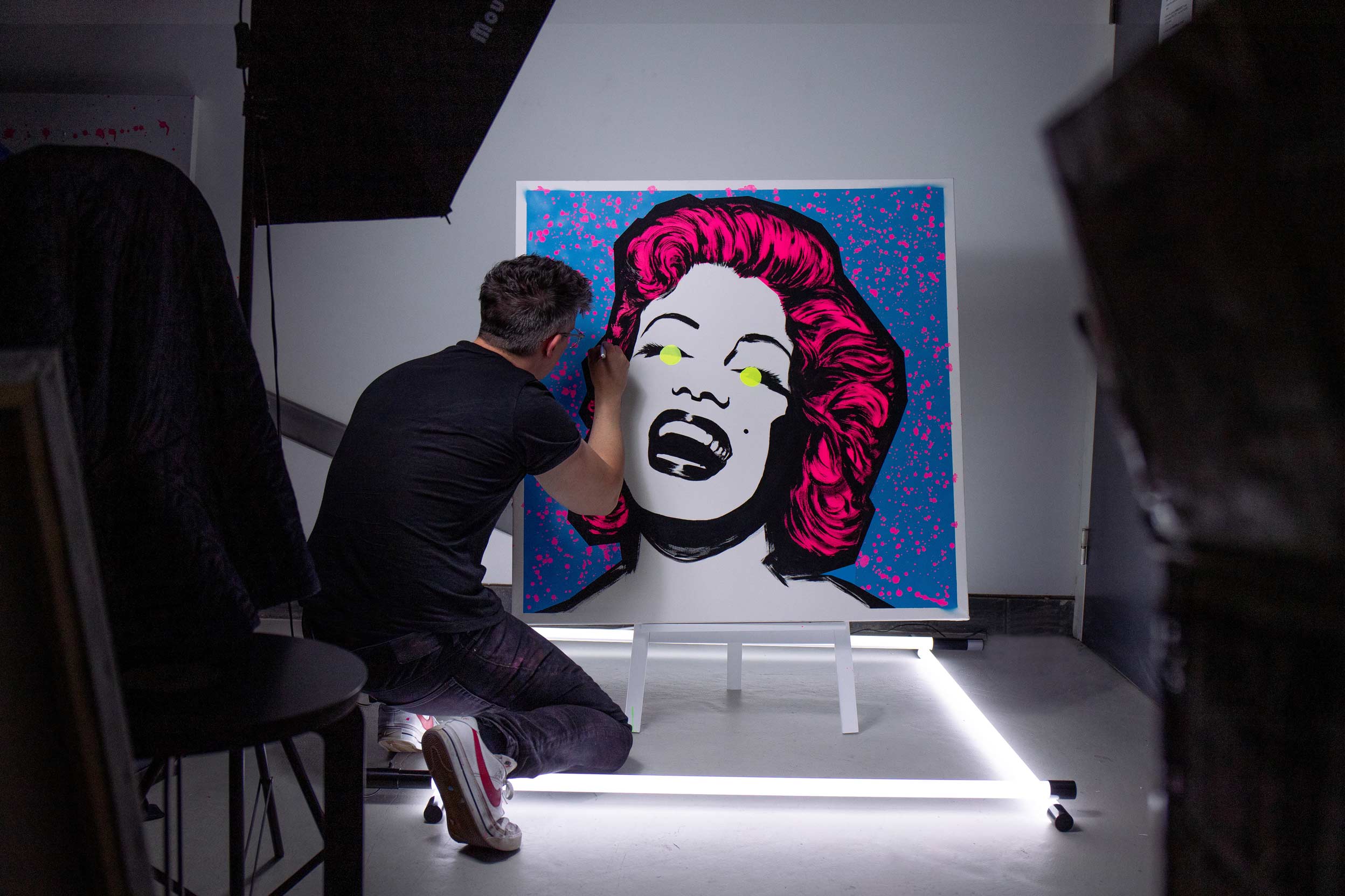 Kyle Wilkinson AKA The Thrill painting a portrait of Marilyn Monroe in blue and pink